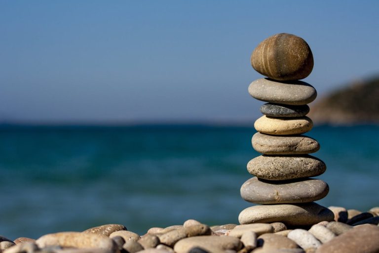 Calm seashore with balanced stones - symbol of inner peace through meditation in Bracknell