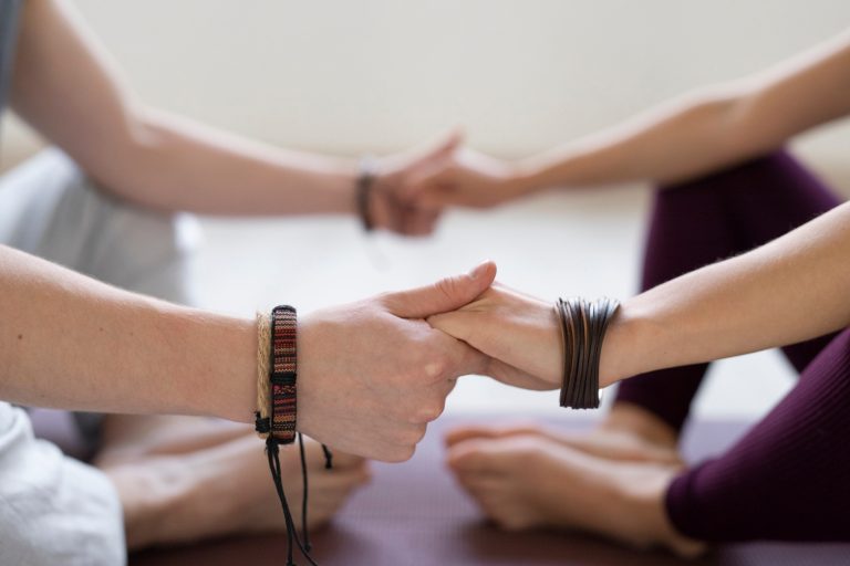 Two participants in a reiki session from Newbury holding hands